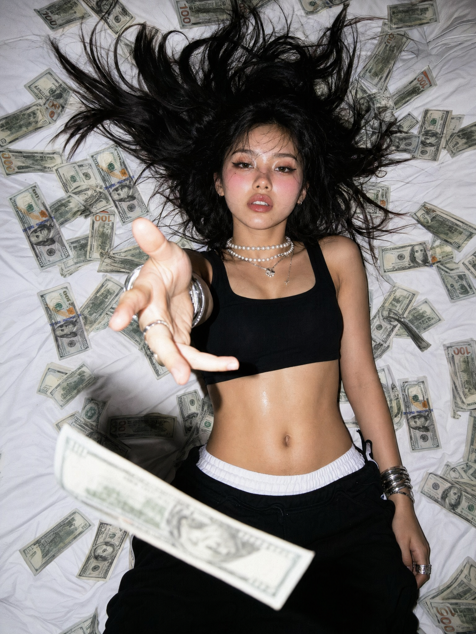 Top-down 90-degree overhead shot of a young slender woman lying supine on a wri...